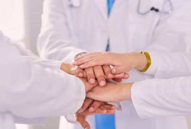 Doktorlar ve hemşireler el ele tutuşuyor. Beyazda izole edilmiş.