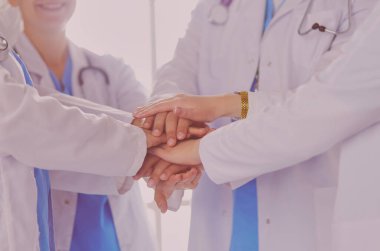 Doktorlar ve hemşireler el ele tutuşuyor. Beyazda izole edilmiş.