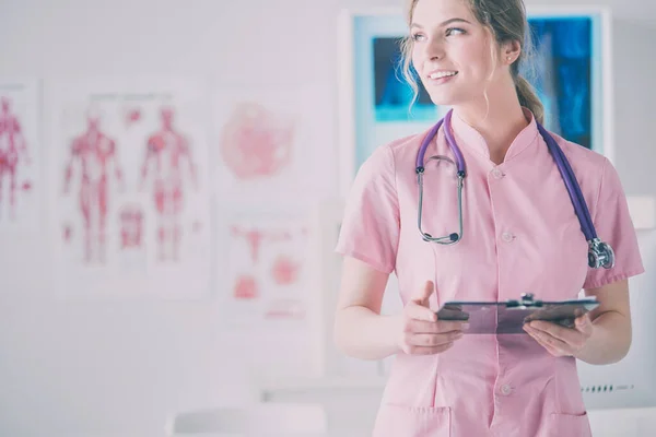 Sorridente Medico Donna Con Una Cartella Uniforme Piedi Ospedale — Foto Stock