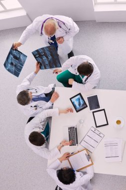 Tıbbi ekip masaya oturuyor ve tartışıyor..