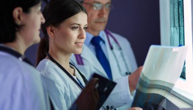 Bir grup doktor hastanede röntgenlere bakıyor.