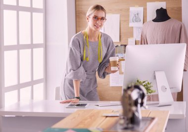 Moda tasarımcısı kadın dikiş makinesiyle dikiş dikiyor.