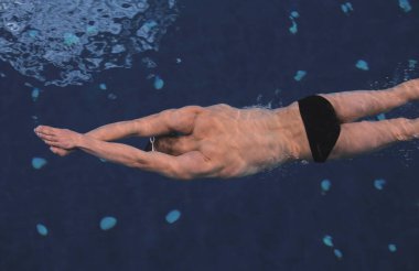 Yüzme havuzunda erkek yüzücü. Su altı fotoğrafı. Erkek yüzücü