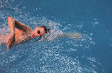 Yüzme havuzunda erkek yüzücü. Su altı fotoğrafı. Erkek yüzücü