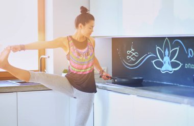 Formda ve çekici genç bir kadın sağlıklı yemek hazırlıyor. Kadın