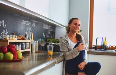 Mutfakta masada oturan genç bir kadın.