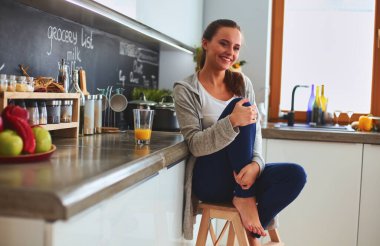 Mutfakta masada oturan genç bir kadın.