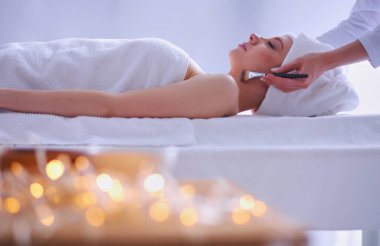 Masaj masasında uzanmış gözleri kapalı rahatlayan genç bir kadın. - Kadın. Spa salonu.
