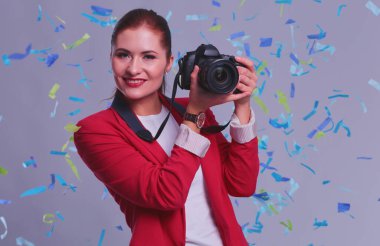 Kamera ile konfeti kutlama partisinde güzel mutlu kadınla. Doğum günü veya yeni yıl arifesi kavramı kutlama.