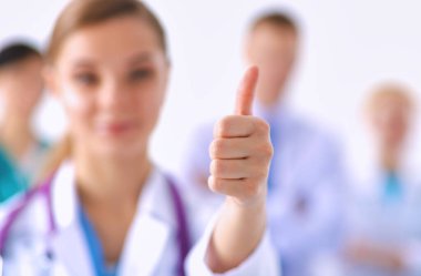 Genç, mutlu kadın doktor baş parmağını gösteriyor..