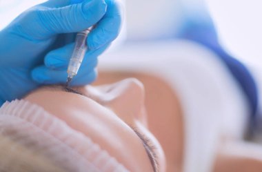 Kaşlar için kalıcı makyaj. Güzellik salonunda kalın kaşlı güzel bir kadın..