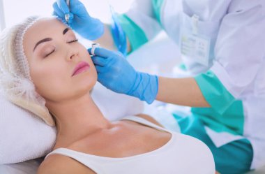 Kaşlar için kalıcı makyaj. Güzellik salonunda kalın kaşlı güzel bir kadın..