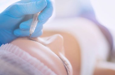 Kaşlar için kalıcı makyaj. Güzellik salonunda kalın kaşlı güzel bir kadın..