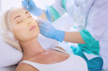 Kaşlar için kalıcı makyaj. Güzellik salonunda kalın kaşlı güzel bir kadın..