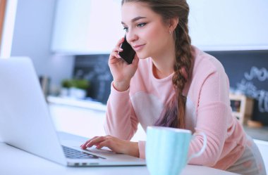 Gülümseyen kadın mutfakta tablet ve kredi kartı kullanarak alışveriş online .