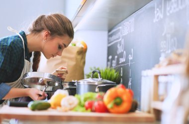 Gülümseyen kadın mutfakta tablet ve kredi kartı kullanarak alışveriş online .