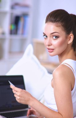 Kadın kredi kartı ve bilgisayarla online alışveriş yapıyor. İnternet alışverişi..