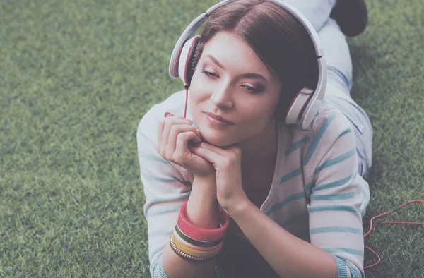 Młoda Kobieta Słuchanie Muzyki Leżącego Zielonej Trawie — Zdjęcie stockowe