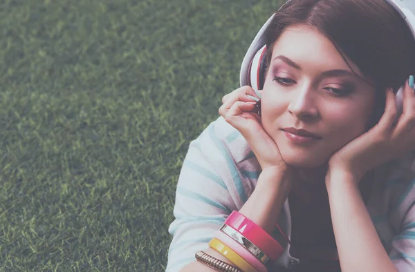 Junge Frau Hört Musik Auf Grünem Gras Liegend — Stockfoto