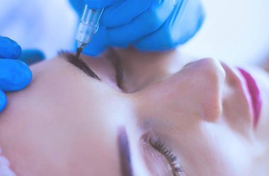 Kaşlar için kalıcı makyaj. Güzellik salonunda kalın kaşlı güzel bir kadın..