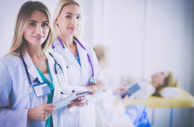 Tıp ofisinde kollarını kavuşturmuş kendine güvenen kadın doktorların portresi..