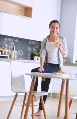 Gülümseyen kadın mutfakta tablet ve kredi kartı kullanarak alışveriş online .