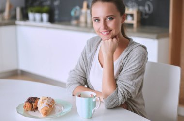 Gülümseyen kadın mutfakta tablet ve kredi kartı kullanarak alışveriş online .