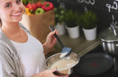 Gülümseyen kadın mutfakta tablet ve kredi kartı kullanarak alışveriş online .