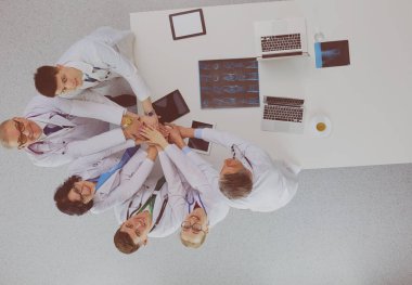 Tıbbi ekip masaya oturuyor ve tartışıyor..