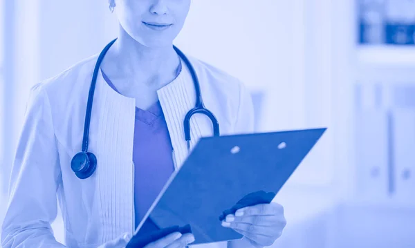 Joven Doctora Sonriente Con Estetoscopio Sosteniendo Una Carpeta Consultorio Médico — Foto de Stock