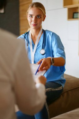 Doktor ve hasta masada otururken bir şey tartışıyorlar. İlaç ve sağlık hizmetleri kavramı.