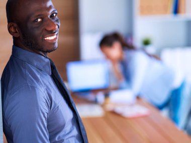 İş kadını ofisinde tablet bilgisayar kullanarak oturuyor..