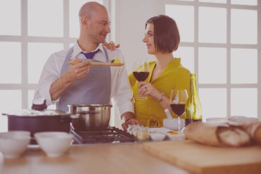 Aşık çekici bir çift yemek pişirir ve onlar romantik bir akşam yemeği pişirirken mutfakta şarap açar..