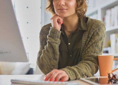 Çevrimiçi eğitim hizmetini kullanan güzel, gülümseyen kız öğrenci.