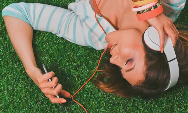 Yeşil çimlerde oturan genç bir kadın. Portreit genç bayan.