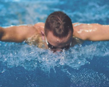 Yüzme havuzunda erkek yüzücü. Su altı fotoğrafı. Erkek yüzücü