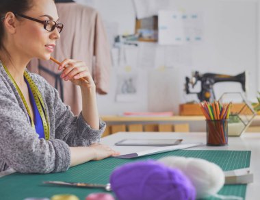 Moda tasarımcısının stüdyosunda çalışan portresi..