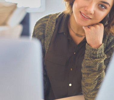 Evde tablet bilgisayar kullanan genç bir kadın ya da öğrenci.