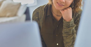 Evde tablet bilgisayar kullanan genç bir kadın ya da öğrenci.