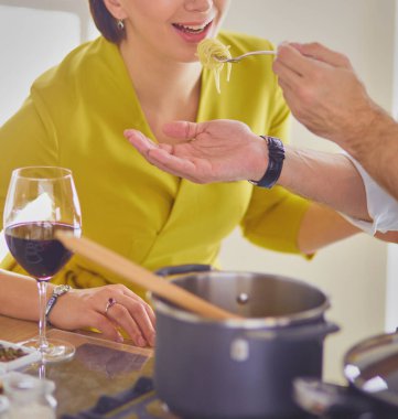 Evdeki mutfakta birlikte yemek pişiren çift..