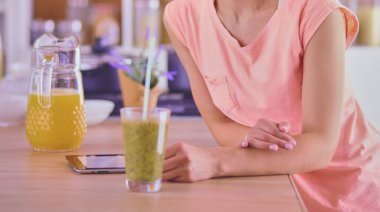 Mutfakta dijital tablet kullanan güzel genç bir kadın..