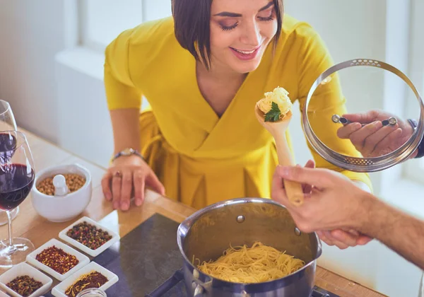 Evdeki mutfakta birlikte yemek pişiren çift..
