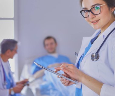 Hastane lobisinde tablet bilgisayar kullanan kadın doktor.,