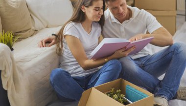 Yeni evlerinde karton kutuları açan sevimli bir çift. Üst görünüm