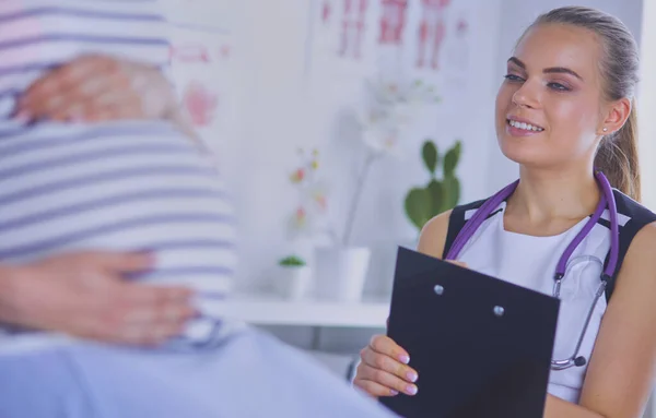 Fiatal Orvos Sztetoszkóppal Tablettával Beszél Terhes Nővel Kórházban — Stock Fotó