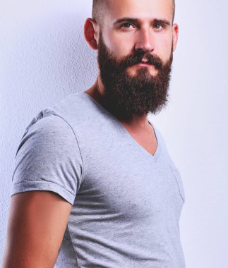 Ayakta, gri arka plan üzerinde izole yakışıklı adam portresi.