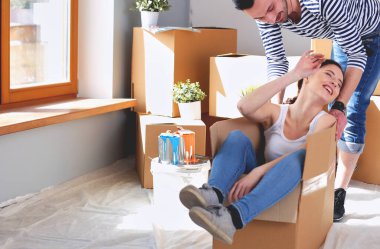 Açma veya kutu ambalaj ve yeni evine taşıdıktan mutlu genç bir çift. Genç Çift.