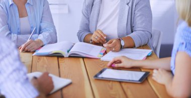 Masada kitaplarla çalışan gençler. Güzel kadınlar ve erkekler birlikte çalışıyor..