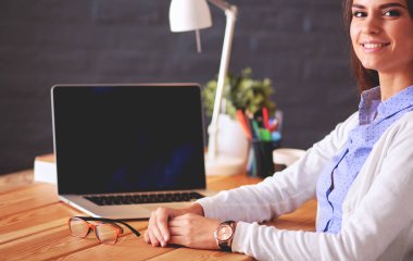 Masada oturan genç bir kadın.