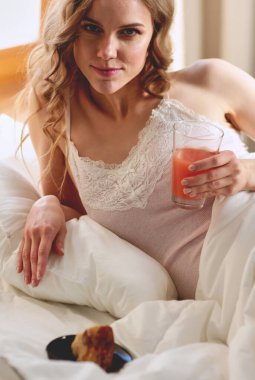 Genç kadın yatakta yatan ise kahve veya çay içme